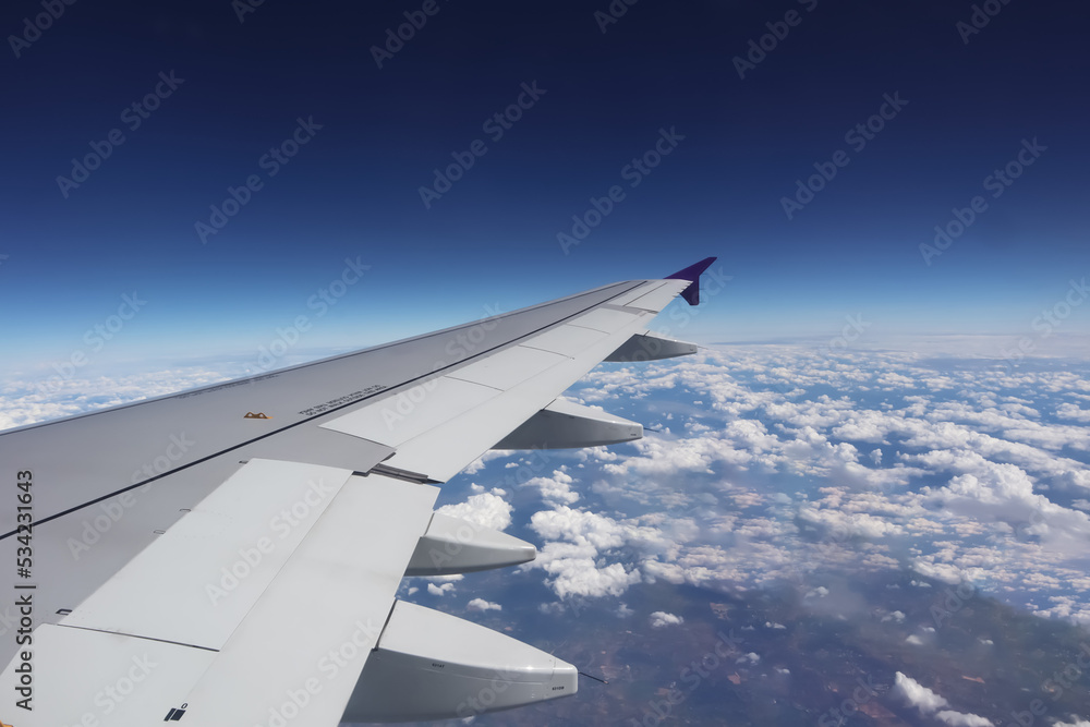 Aerial view from window of aircraft show aircraft wing and engine with horizon deep blue sky above all white clouds for transportation and travel airline business presentation background. Aerial view from window of aircraft show aircraft wing and engine with horizon deep blue sky above all white clouds for transportation and travel airline business presentation background.