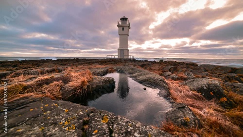 Timelapse of Old lighthouse with reflectionin ice and moving cloudse - Iceland, Akranes time lapse photo