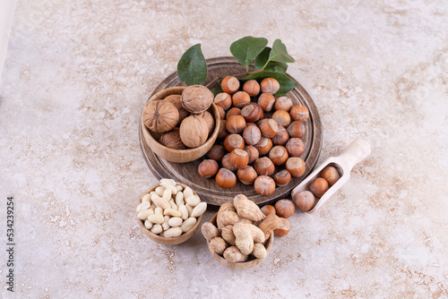A wooden bowl of macadamia nuts and walnuts