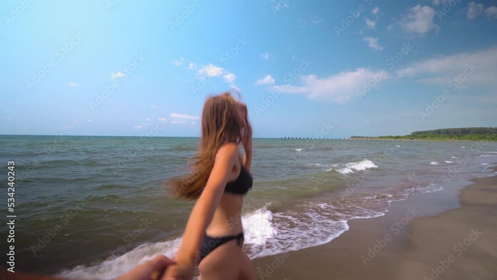 Girl holding male hand and running on tropical exotic beach to ocean. Follow me shot of young woman pull her boyfriend on sea shore. Summer vacation or holiday. POV. Girl holding male hand and running on tropical exotic beach to ocean. Follow me shot of young woman pull her boyfriend on sea shore. Summer vacation or holiday. POV.