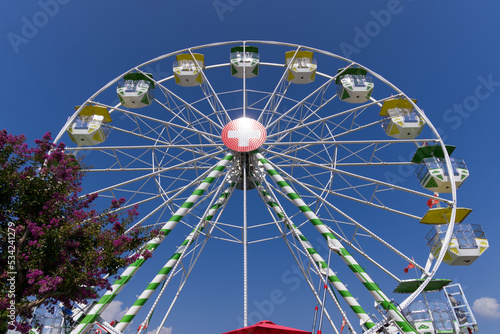 Ferris wheel with Swiss flag at village of Ascona  Canton Ticino  on a sunny summer day. Photo taken July 24th  2022  Ascona  Switzerland.