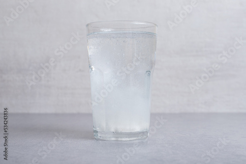 A glass of pure cold water on gray background