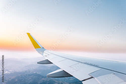 Plane wing in cloudy sky