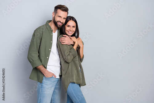 Portrait of attractive tender cute sweet cheerful couple cuddling copy space isolated over grey pastel color background photo