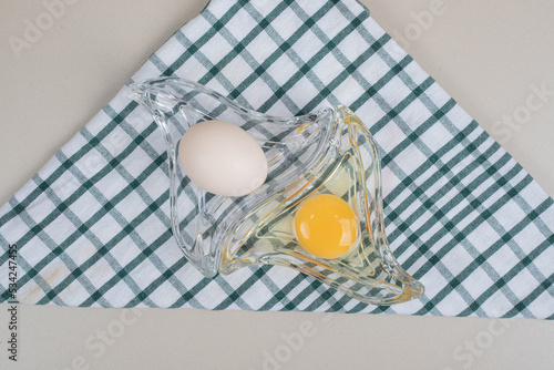 Fresh chicken white eggs with yolk on glass plate photo