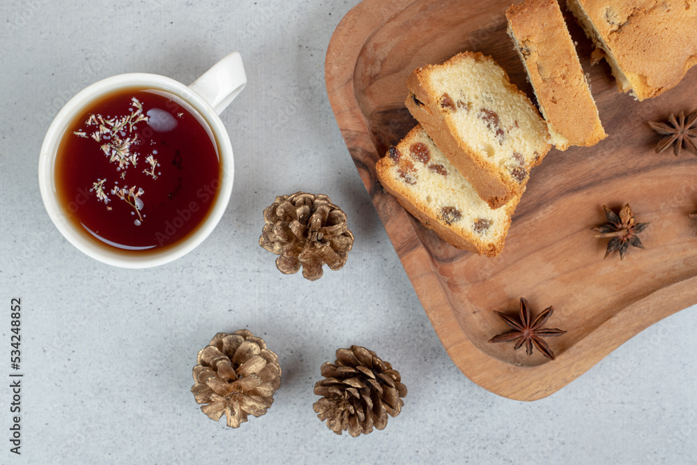 Delicious muffin with raisin and cup of tea on wooden board Delicious muffin with raisin and cup of tea on wooden board
