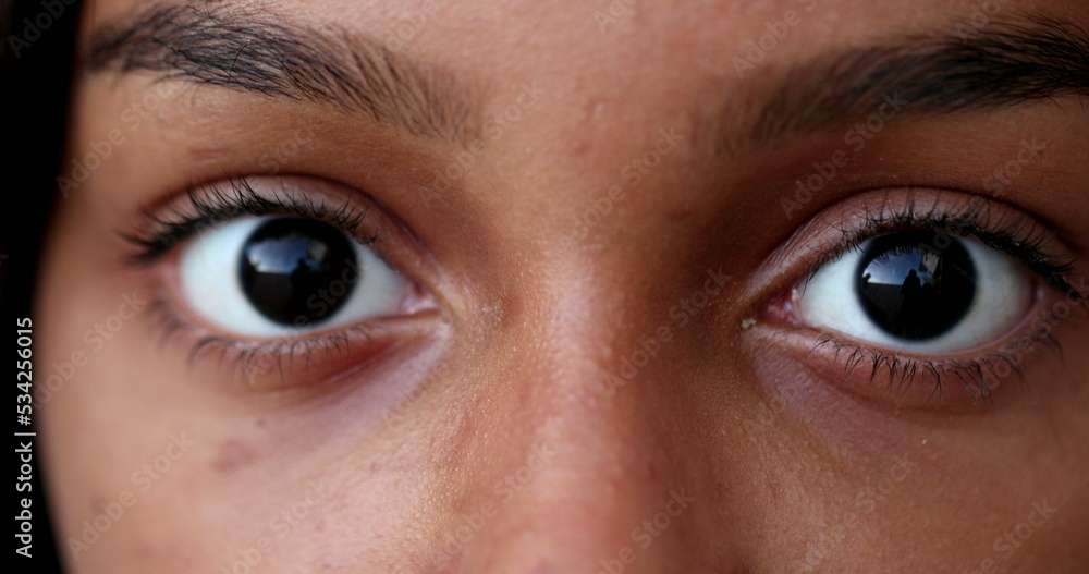 Black child eyes wide open looking at camera macro close-up Black child eyes wide open looking at camera macro close-up