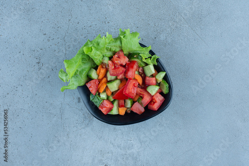 A bowl of shepherd's salad on marble background