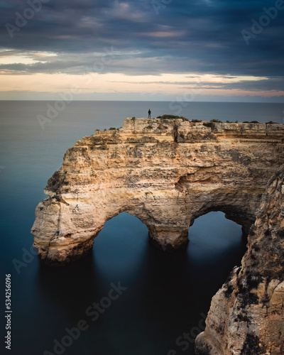 View of a person standing on the cliff in Praia de Mesquita, Algarve, Portugal. photo