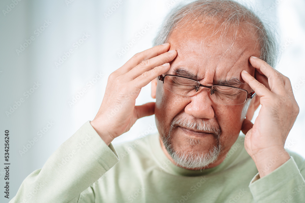 Closeup of Asian Senior elderly old man feel headache suffering and migraine in living room at home. Stressed mature male hurt mental health care and insurance concept. Closeup of Asian Senior elderly old man feel headache suffering and migraine in living room at home. Stressed mature male hurt mental health care and insurance concept.