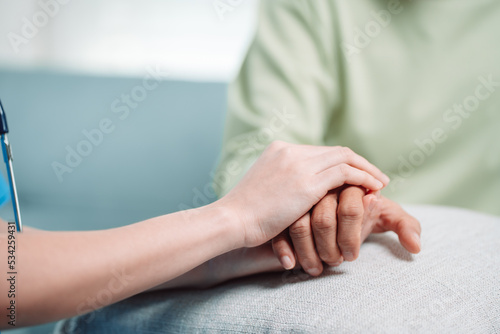 Asian caregiver holding hands senior elderly old male take care mental health care at nursing home.