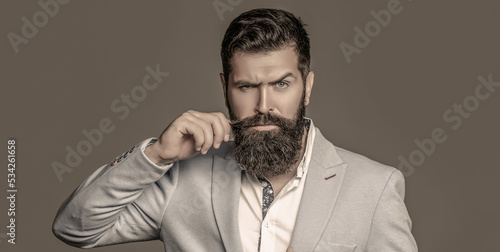 Male beard and mustache. Elegant man in business suit. Sexy male, brutal macho, hipster. Male in tuxedo photo