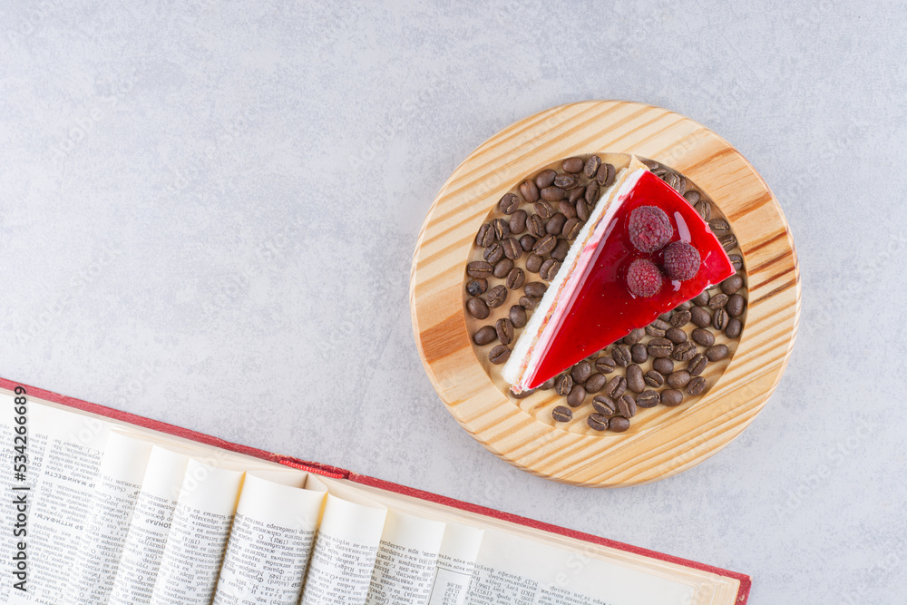 Slice of cheesecake with coffee beans and book