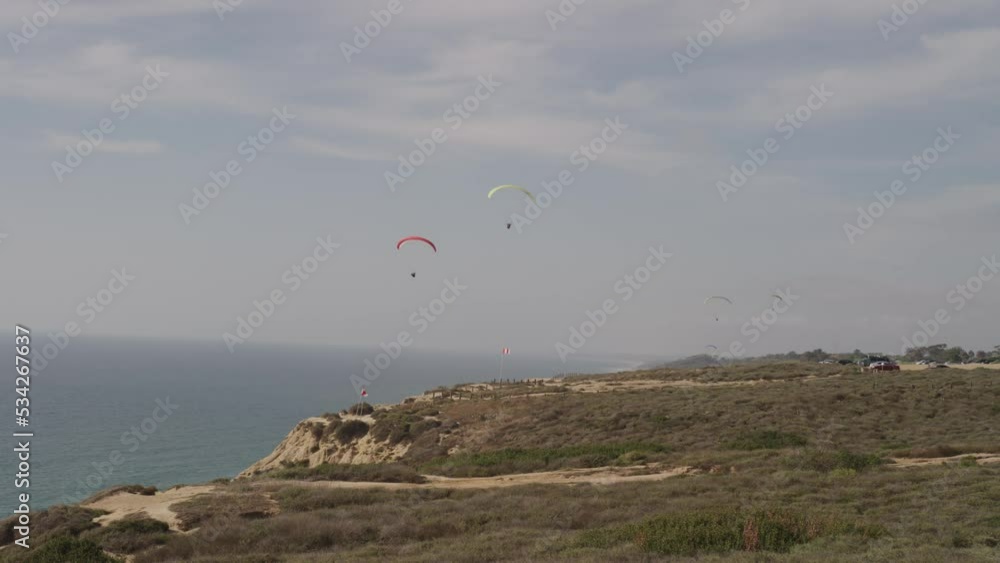 Slow motion of paragliders on coastal bluffs in Southern California in summer Slow motion of paragliders on coastal bluffs in Southern California in summer