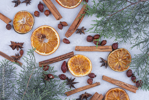 Cinnamon sticks, rosehips and dried orange slices on surface photo