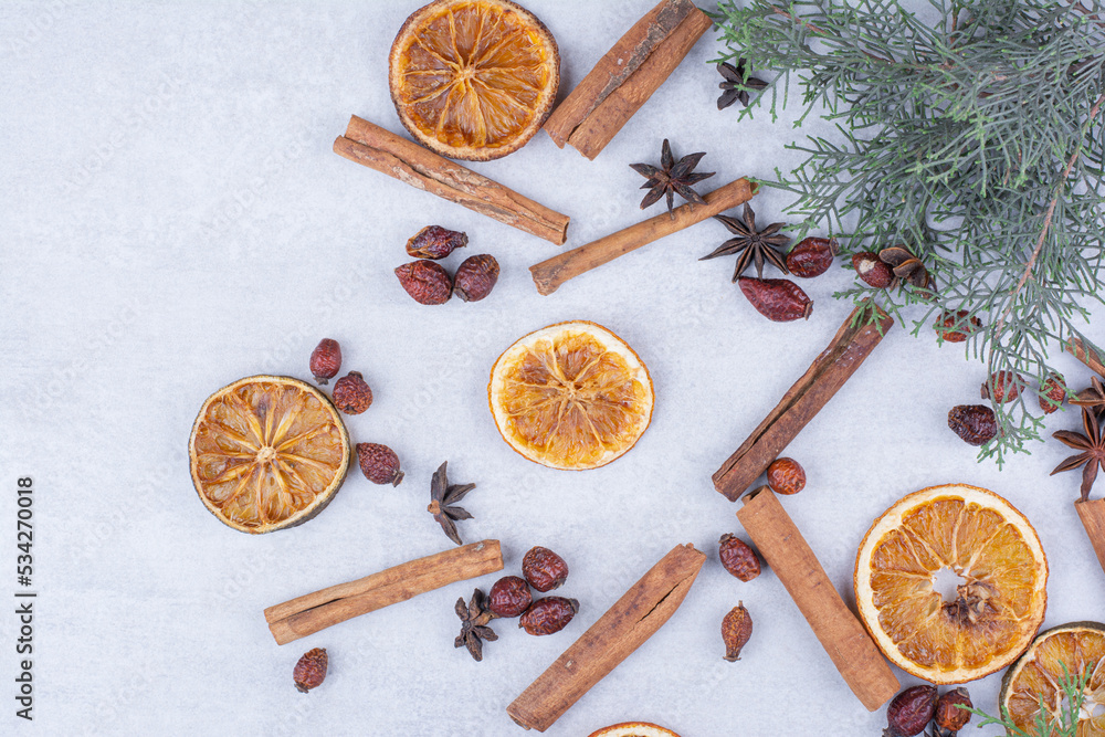 Cinnamon sticks, rosehips and dried orange slices on surface Cinnamon sticks, rosehips and dried orange slices on surface