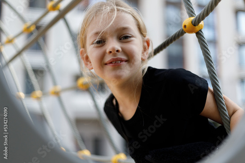 Portrait of a happy child girl on the playground. Carefree active lifestyle.