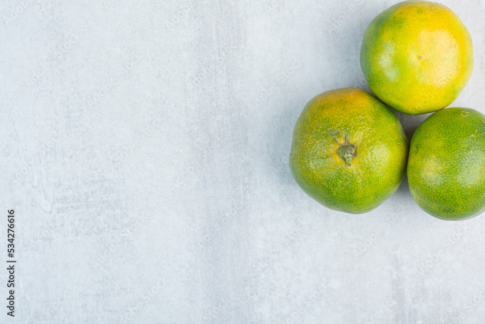 Three fresh tangerines on stone background Three fresh tangerines on stone background
