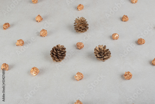 Conifer cones and bits of candied popcorn all over the marble background
