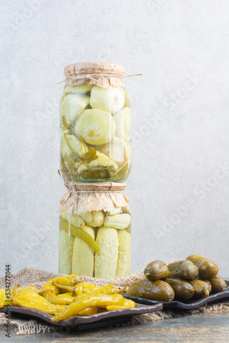 Pickled cucumbers with salty peppers on sackcloth