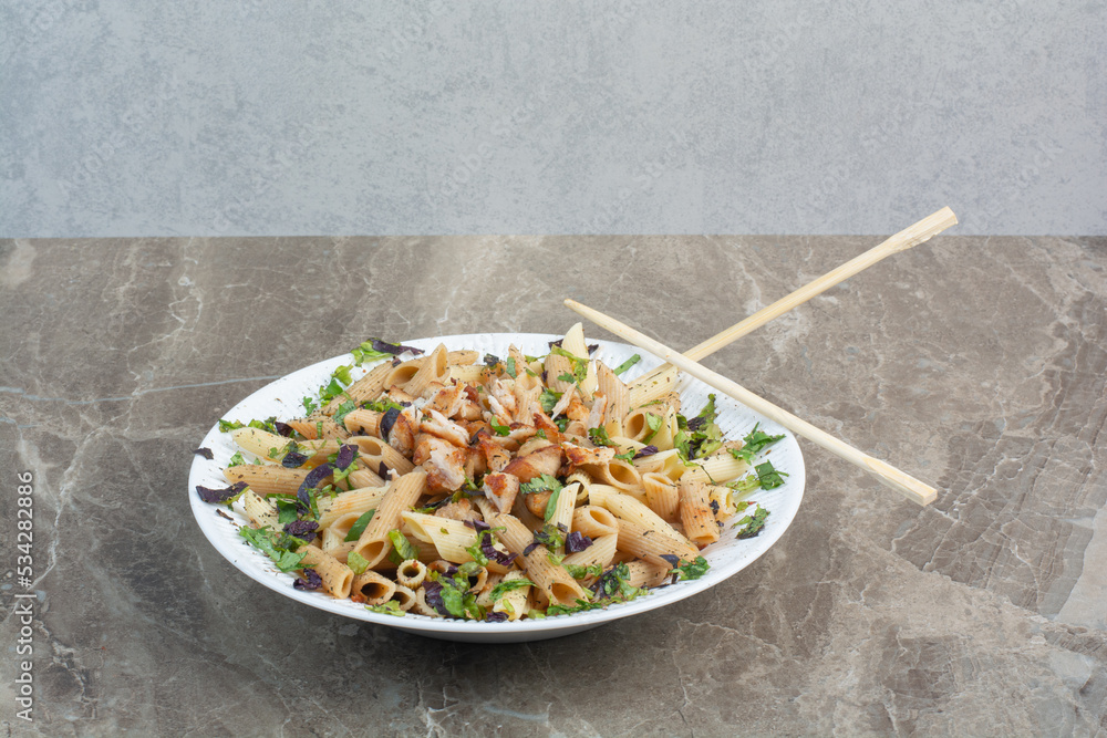 White plate of delicious macaroni with chopsticks White plate of delicious macaroni with chopsticks