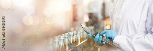 Принти на полотні Hands of worker working with digital tablet check product on the conveyor belt in the beverage factory