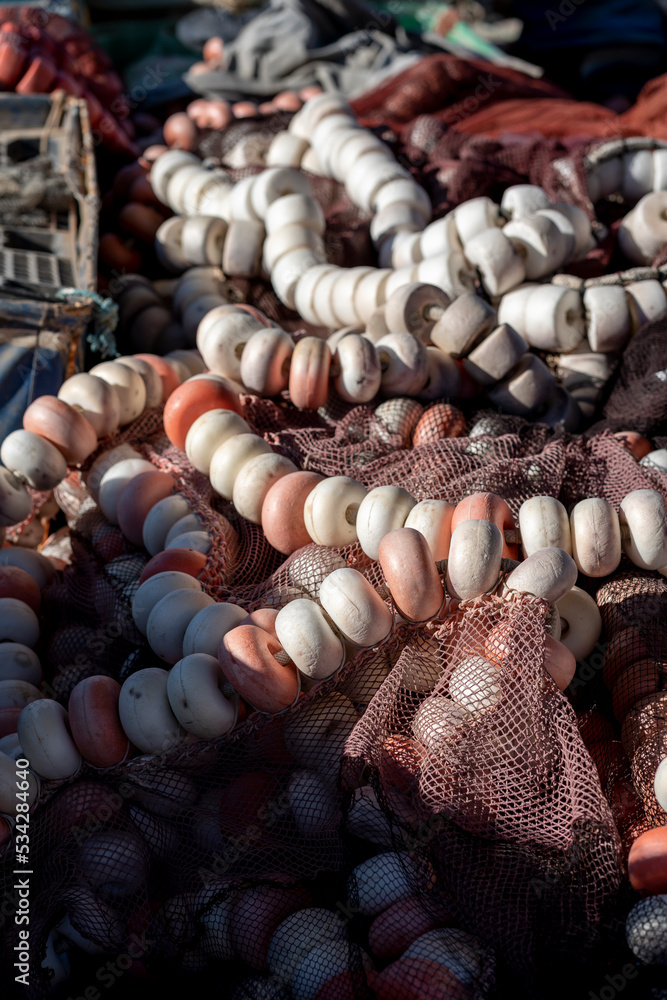 Fishing nets and floats in a port withe sea in the background. Fishing nets and floats in a port withe sea in the background.