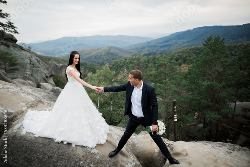 Wallpaper Mural Beautiful gorgeous bride posing to groom and having fun near at mountains with amazing view, space for text, wedding couple Torontodigital.ca
