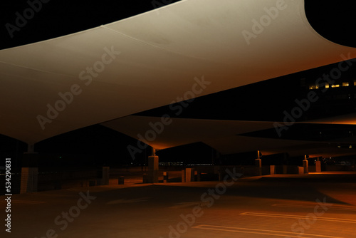 A parking structure area with large sun sail shades at night. © Romar66