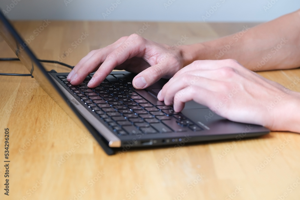 Man are working on notebook, typing on keyboard of laptop Man are working on notebook, typing on keyboard of laptop