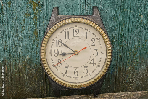 Wallpaper Mural one large old plastic brown black winged clock stands on a gray table against a green wooden wall Torontodigital.ca