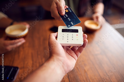 Close Up Of Customer Making Contactless Payment In Coffee Shop Using Debit Card