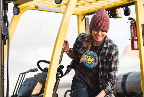 industrial woman forklift driver smiling at a construction site