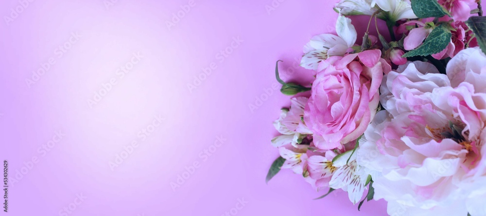 Light pink roses and peonies in a festive bouquet on a light pink background. Delicate floral arrangement. Background for a greeting card.