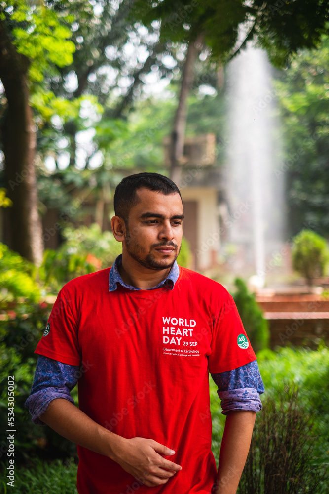 South asian young male medical student wearing red t shirt in awareness about world heart day campaign South asian young male medical student wearing red t shirt in awareness about world heart day campaign