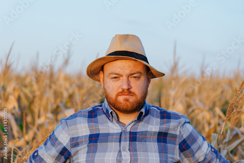 Portrait of a farmer with hat in a field of maize. Man in a rural agricultural environment.