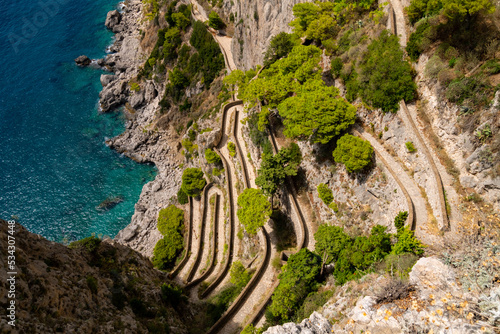 Historic winding walkway connecting Capri village with marina piccola with its beaches and harbour. Paved serpentines of “Via Krupp“ are a famous monument on the coast of touristic island in Italy.