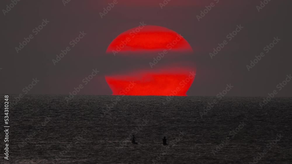 Timelapse of a red sun sunset in the sea. Picturesque seascape in the evening at sunset. People silhouettes sun background. Tourism and travel concept Timelapse of a red sun sunset in the sea. Picturesque seascape in the evening at sunset. People silhouettes sun background. Tourism and travel concept