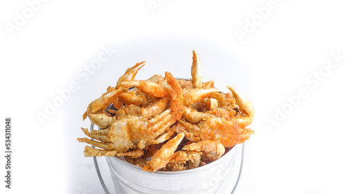 A serving of fried baby crabs in metal bucket, a traditional and famous street found isolated over white background.