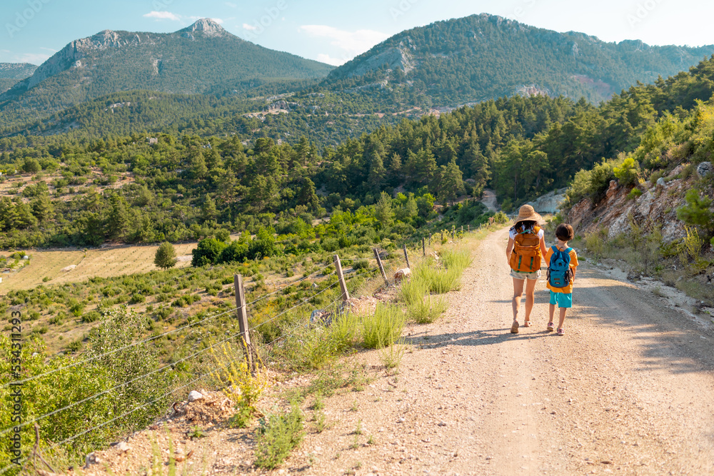 Obraz premium The boy with his mother go hiking.