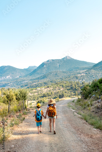 The boy with his mother go hiking.