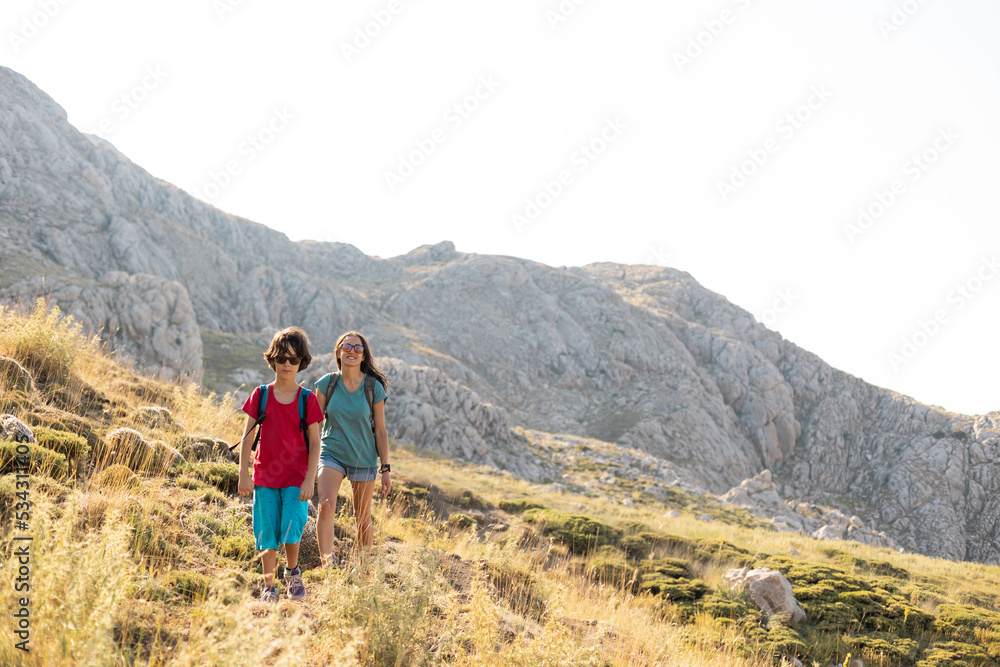 mother with a child on a hike walk along the road