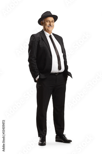 Elegant mature man in black suit and tie wearing a fedora hat © Ljupco Smokovski