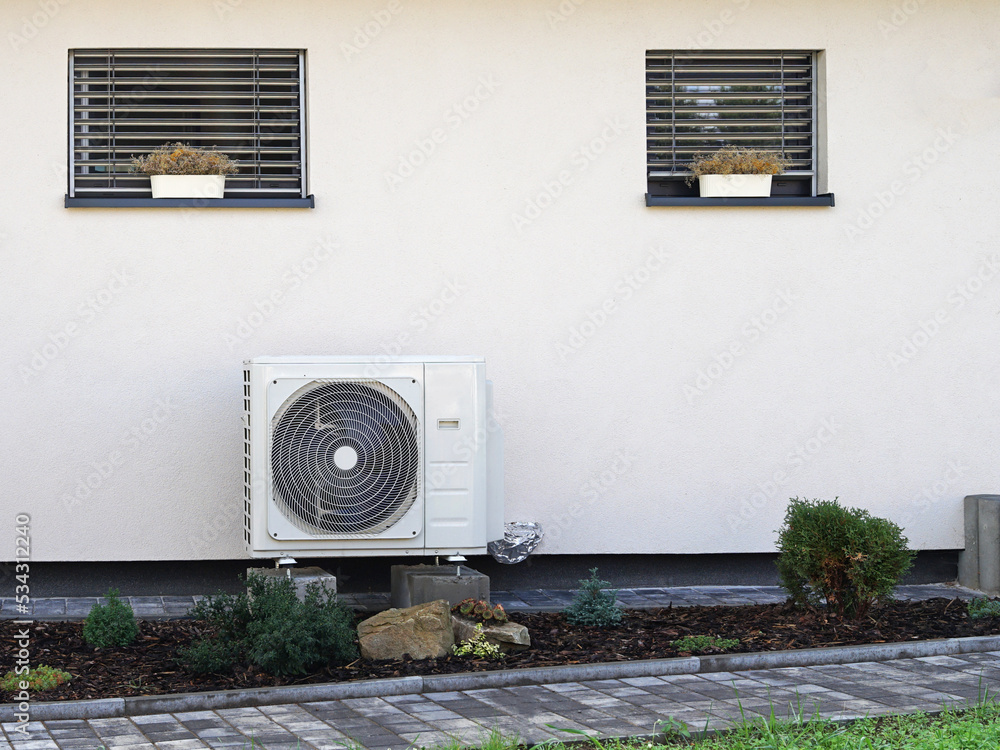 Heat pump or air conditioning outdoor unit in modern house of future using green electric energy, heat pump - efficient source of heat