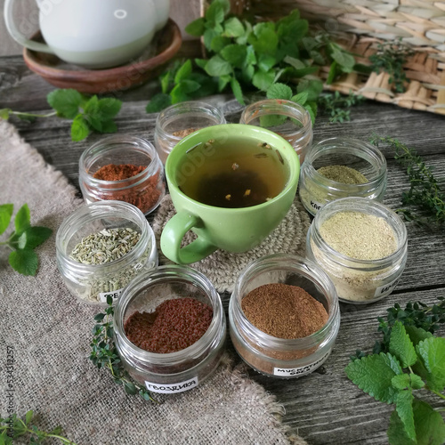 Healing herbs on wooden table with the cup of tea.