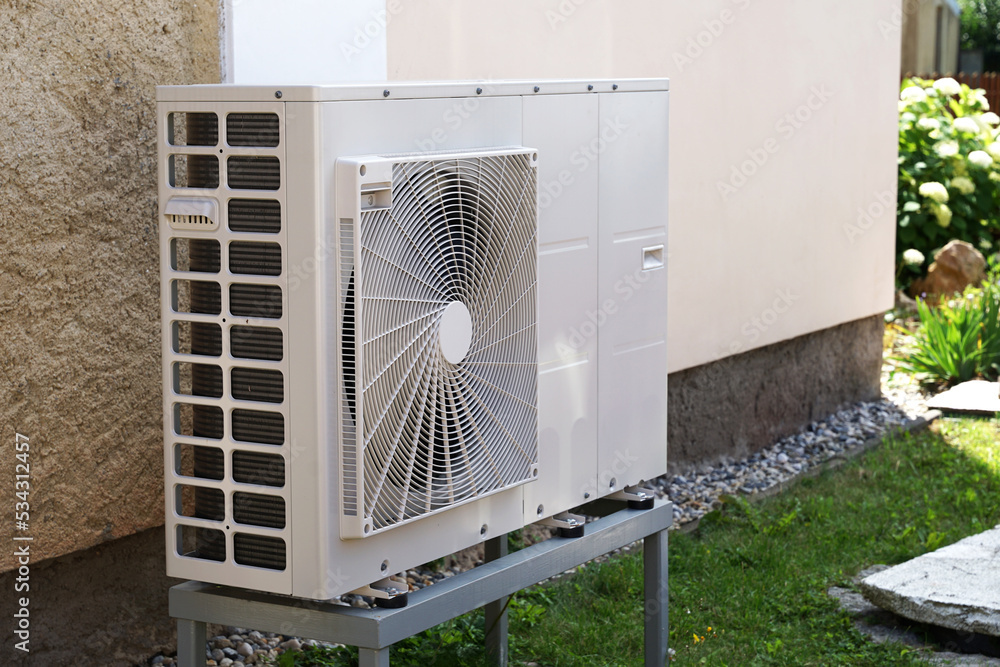 Heat pump or air conditioning outdoor unit in modern house of future using green electric energy, heat pump - efficient source of heat