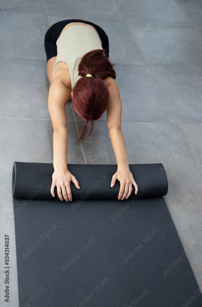 Athlete girl unfolds a yoga mat, top view and a lot of space for an