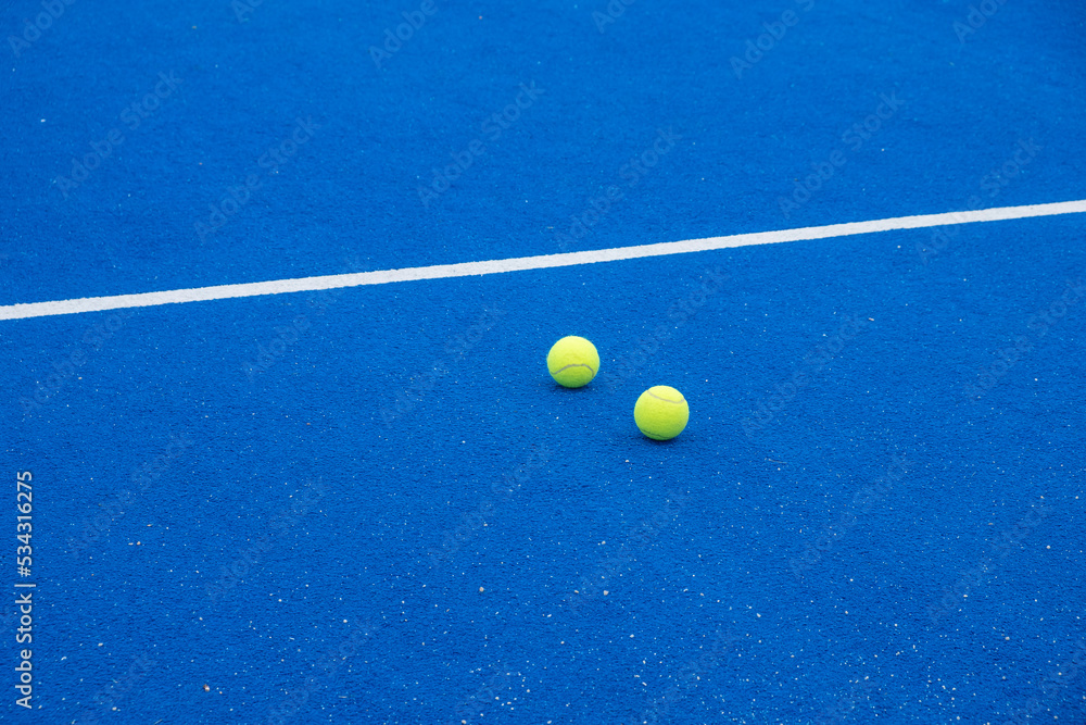 selective focus, two tennis balls on a blue paddle tennis court, racket sports