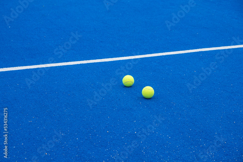 selective focus, two tennis balls on a blue paddle tennis court, racket sports © Vic
