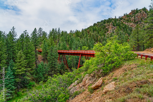 red, steel, trestle bridge called Bridge No. 10 or Adelaide Bridge, built 1894 for the Florence and Cripple Creek Railroad, converted to roadway use in 1912, Phantom Canyon Road over Eightmile Creek